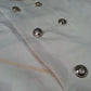 Light beige trench jacket close-up with round metallic buttons
