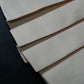 Folded light-colored fabric panels with stitched edges
