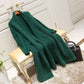 Green knit cardigan sweater draped over a chair